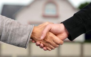 Handshake in front of new home